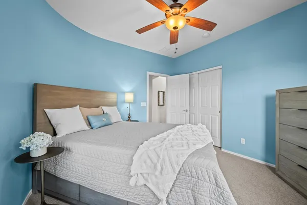 a bedroom with a large bed and a chandelier
