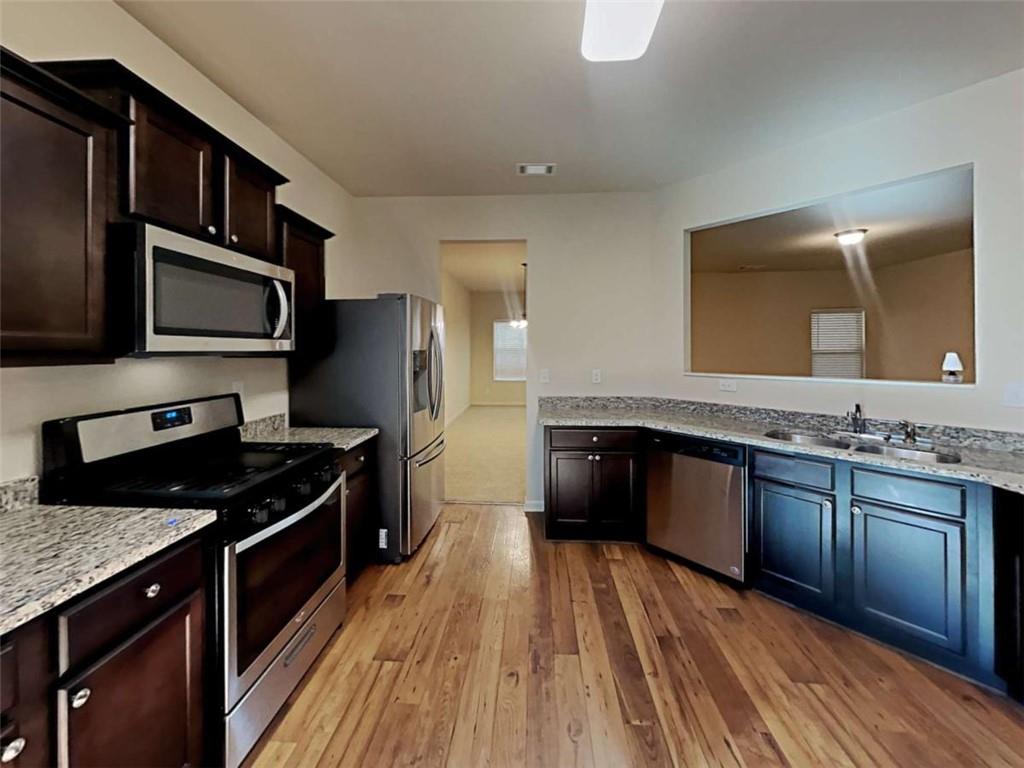 557 Scotland Drive Dallas, GA 30132 - Photo 6 of 28 a kitchen with stainless steel appliances granite countertop a stove a sink and a microwave