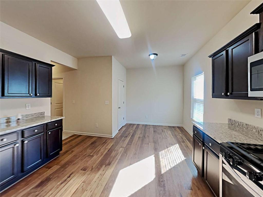 557 Scotland Drive Dallas, GA 30132 - Photo 7 of 28 a kitchen with a wooden floor and a stove top oven