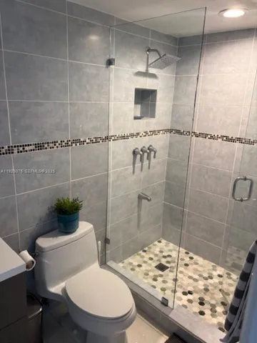 a bathroom with a shower a toilet and a sink