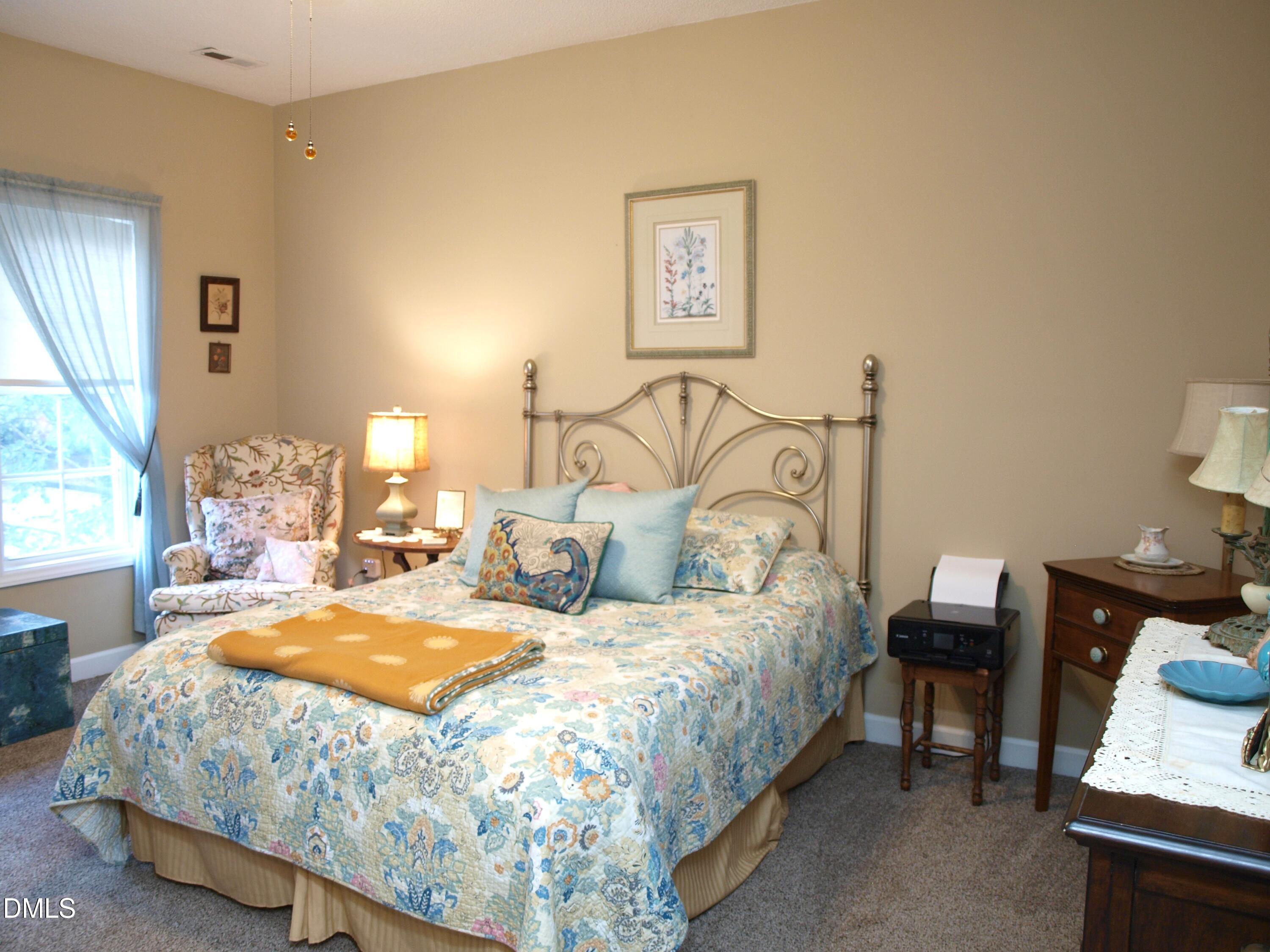 801 Genford Court Raleigh, NC 27609 - Photo 12 of 18 a bedroom with a bed and wooden floor