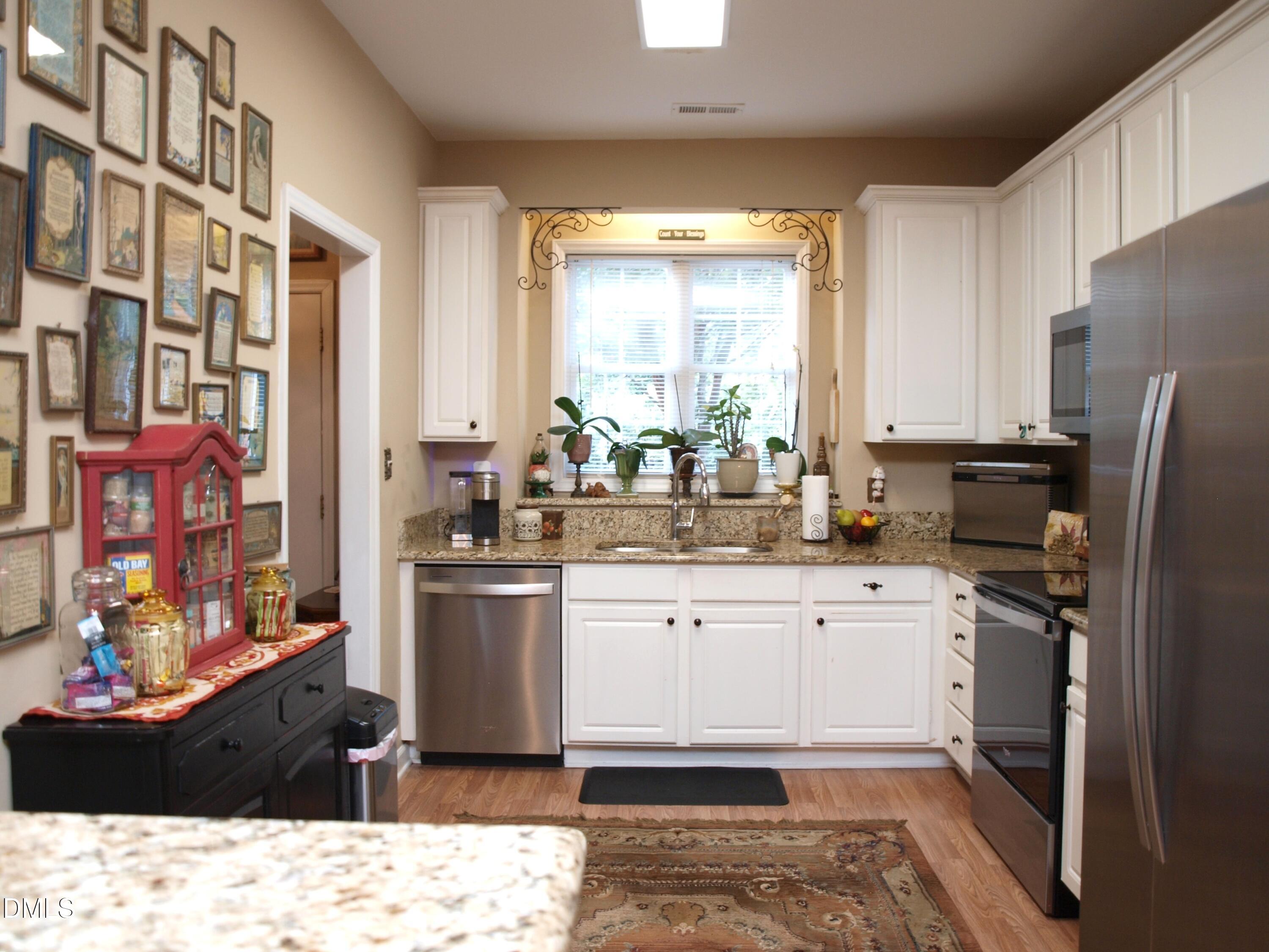 801 Genford Court Raleigh, NC 27609 - Photo 2 of 18 a kitchen with stainless steel appliances kitchen island granite countertop a refrigerator stove top oven and sink