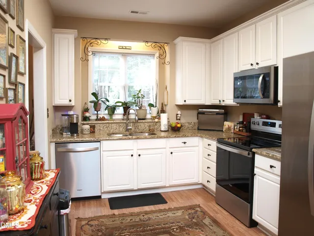 a kitchen with stainless steel appliances granite countertop a stove a sink and a microwave