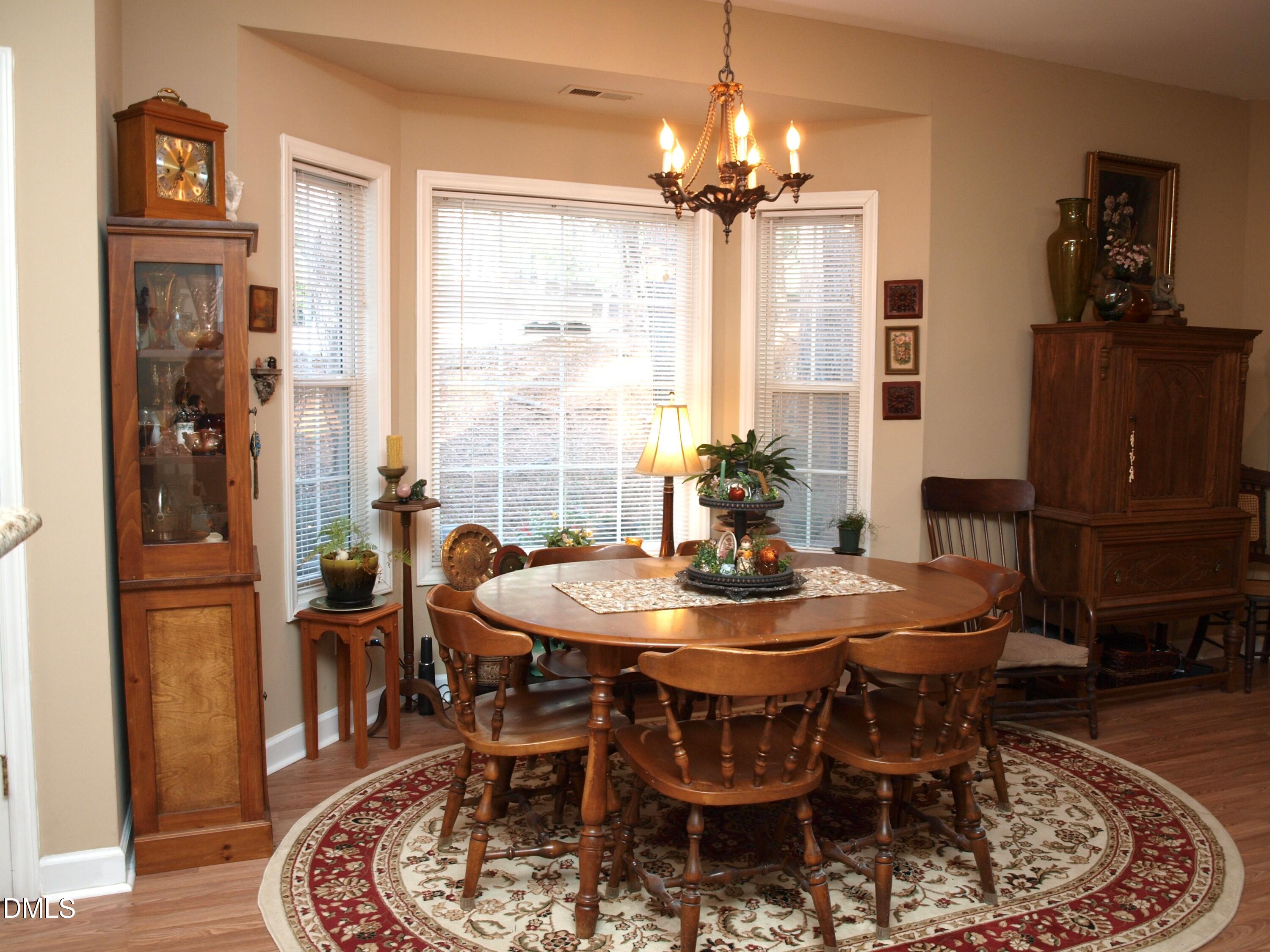 801 Genford Court Raleigh, NC 27609 - Photo 5 of 18 a dining room with furniture a chandelier and wooden floor
