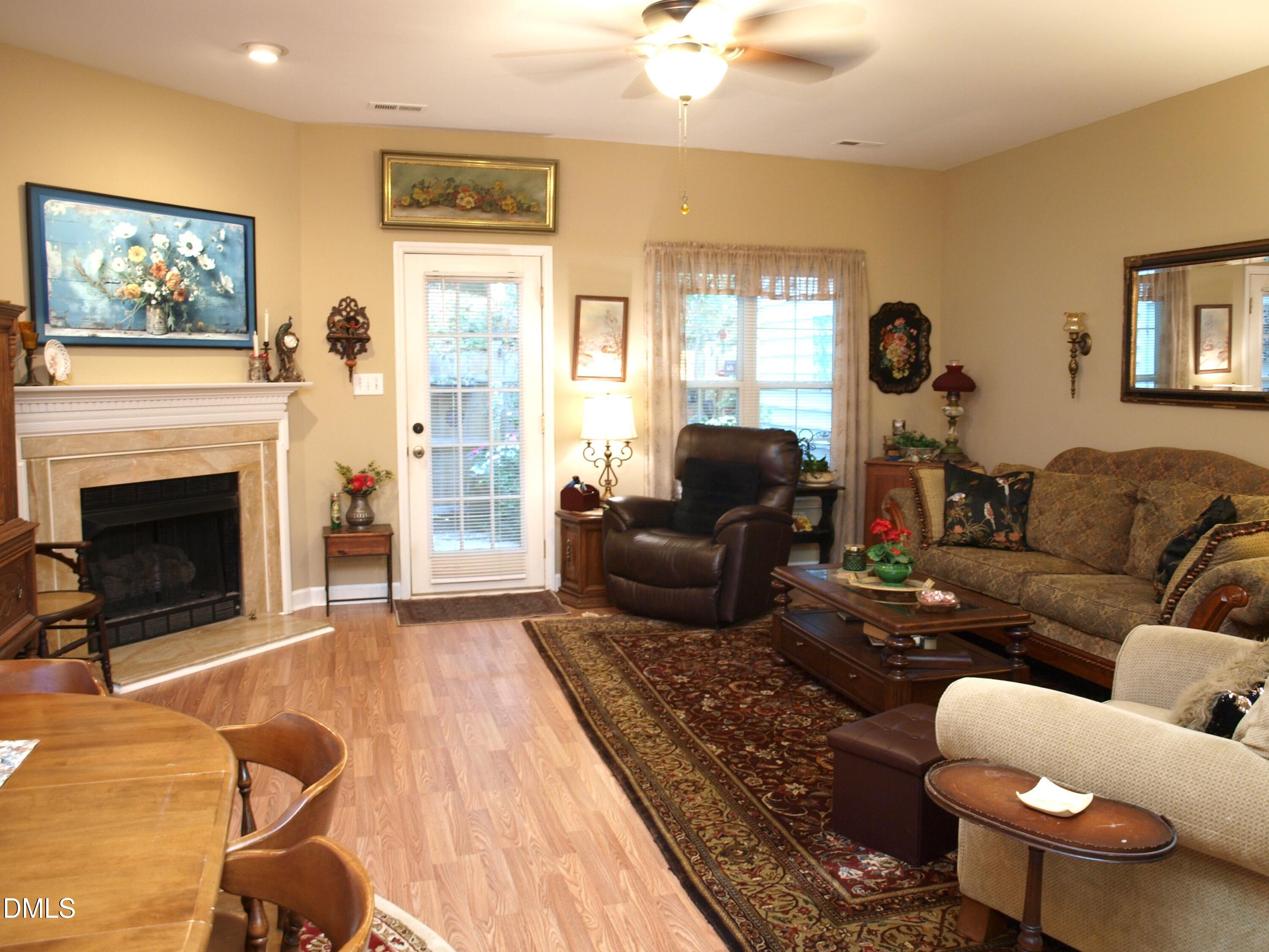 801 Genford Court Raleigh, NC 27609 - Photo 7 of 18 a living room with furniture a fireplace and a flat screen tv