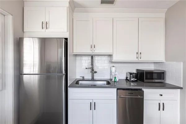 a kitchen with appliances a sink and cabinets