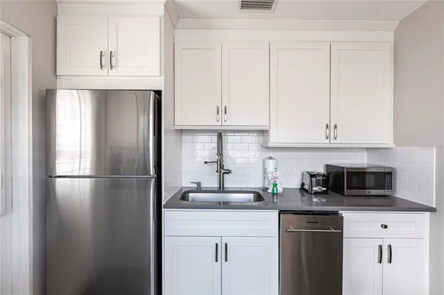 a kitchen with appliances a sink and cabinets