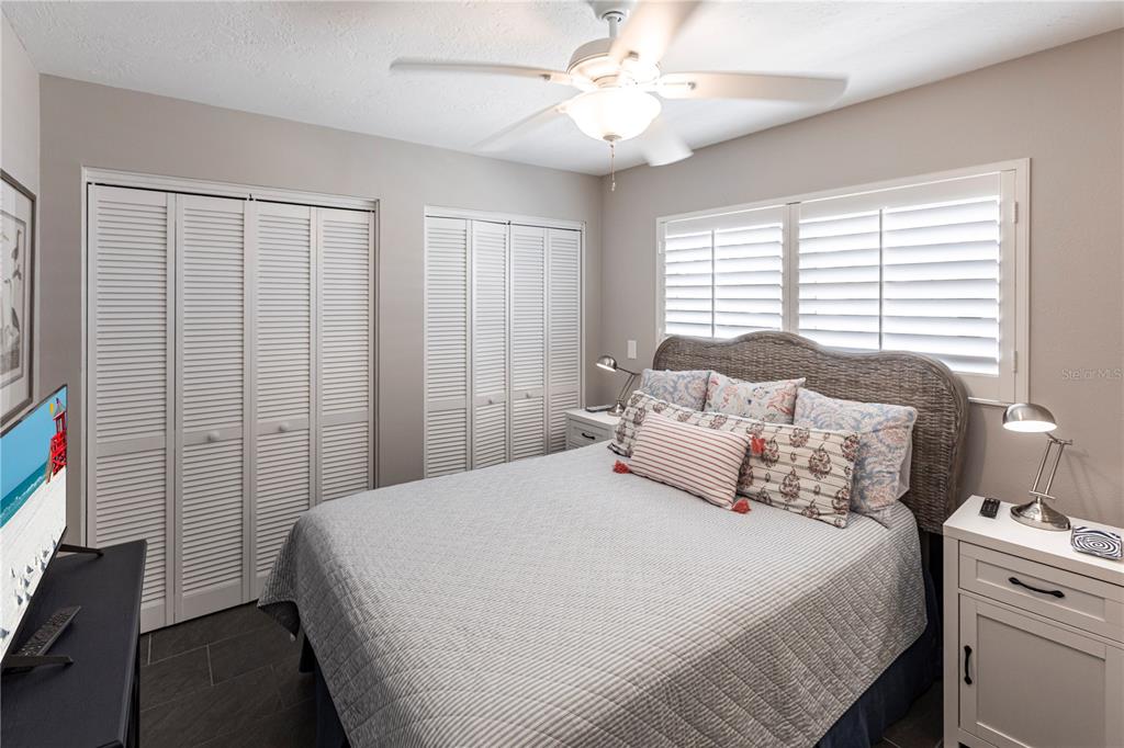 6020 Midnight Pass Road, Unit 31 Sarasota, FL 34242 - Photo 8 of 19 a bedroom with a large bed and a chandelier