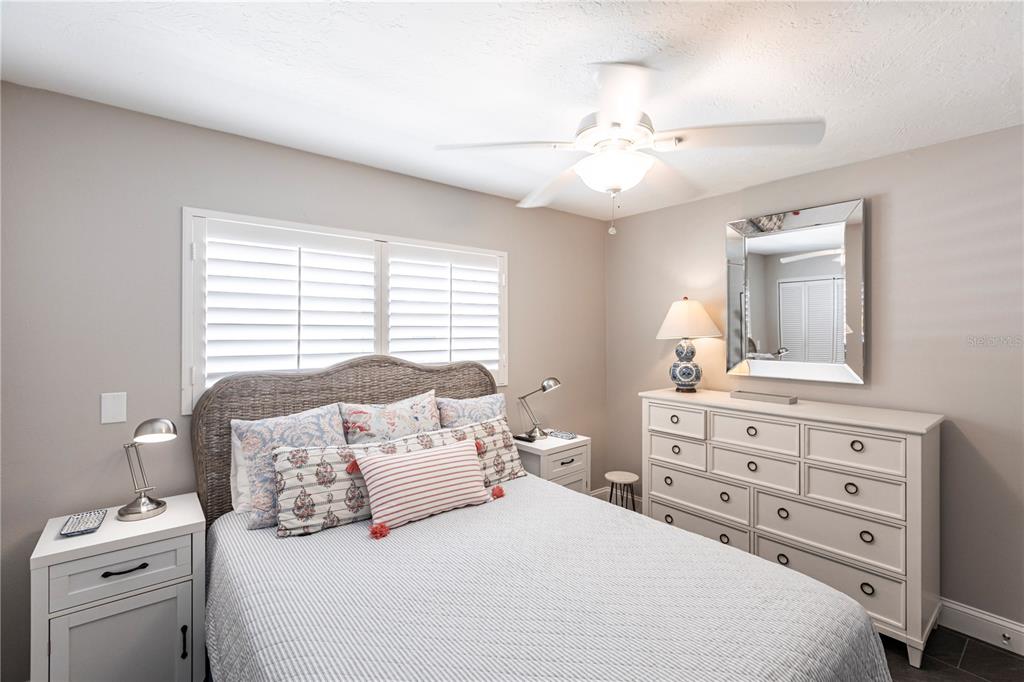 6020 Midnight Pass Road, Unit 31 Sarasota, FL 34242 - Photo 9 of 19 a bedroom with a large bed and a chandelier