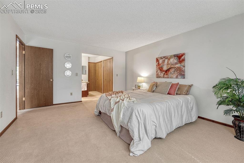1146 Fontmore Road, Unit A Colorado Springs, CO 80904 - Photo 13 of 26 a spacious bedroom with a bed and a painting on the wall