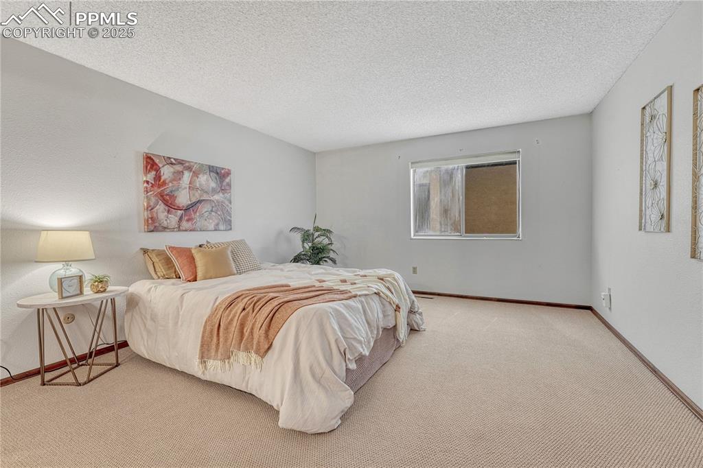 1146 Fontmore Road, Unit A Colorado Springs, CO 80904 - Photo 15 of 26 a spacious bedroom with a bed and a wall painting