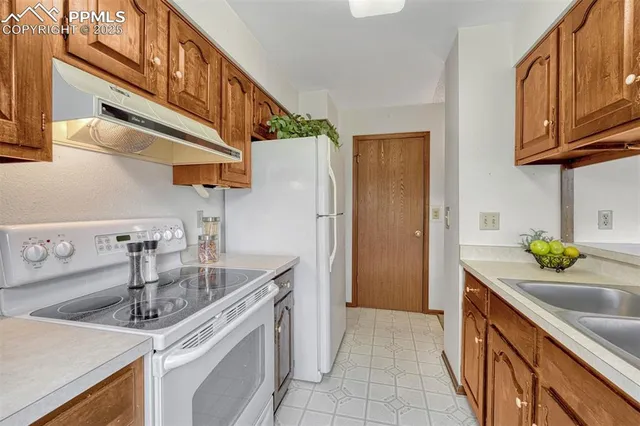 a kitchen with stainless steel appliances granite countertop a sink and a refrigerator