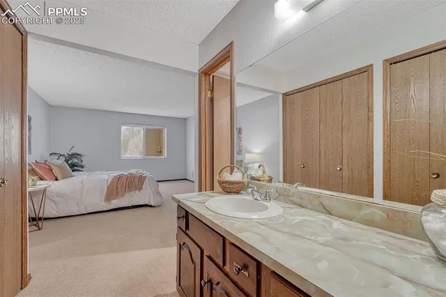 a en suite bathroom with a granite countertop sink and a mirror