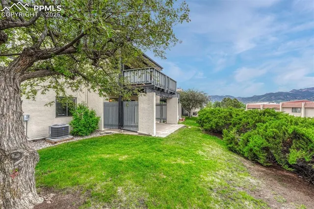 a view of a house with a big yard plants and large trees