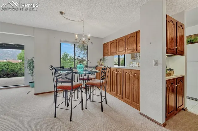 a dining room with furniture a chandelier and window