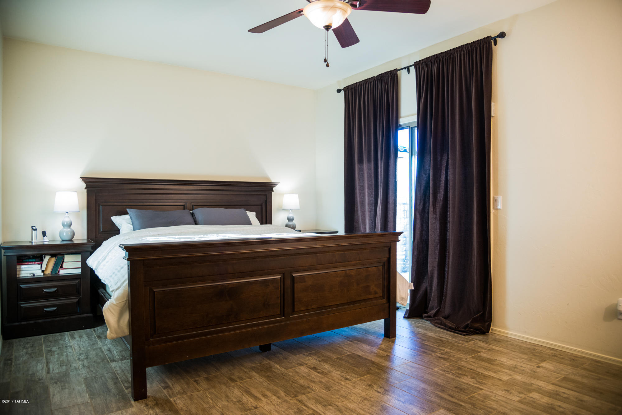 4405 West Crystal Ranch Place Marana, AZ 85658 - Photo 24 of 44 a bed sitting in a bedroom next to a window and a chandelier