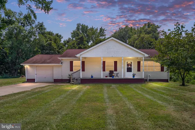 a front view of a house with a garden and yard