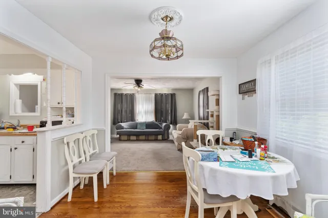 a view of a dining room with furniture a chandelier and wooden floor
