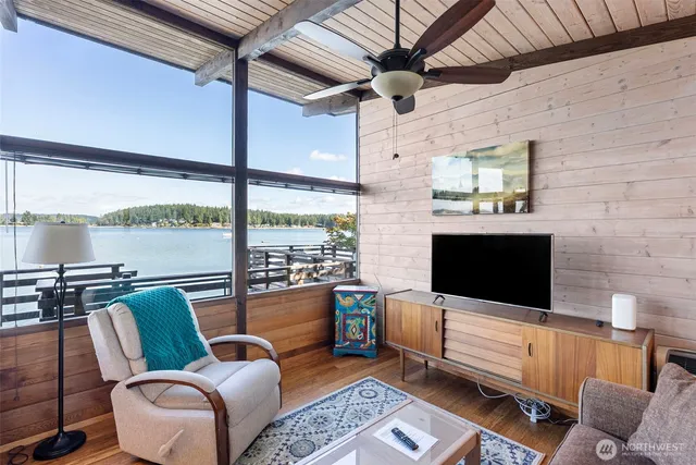 a living room with furniture a flat screen tv and a floor to ceiling window