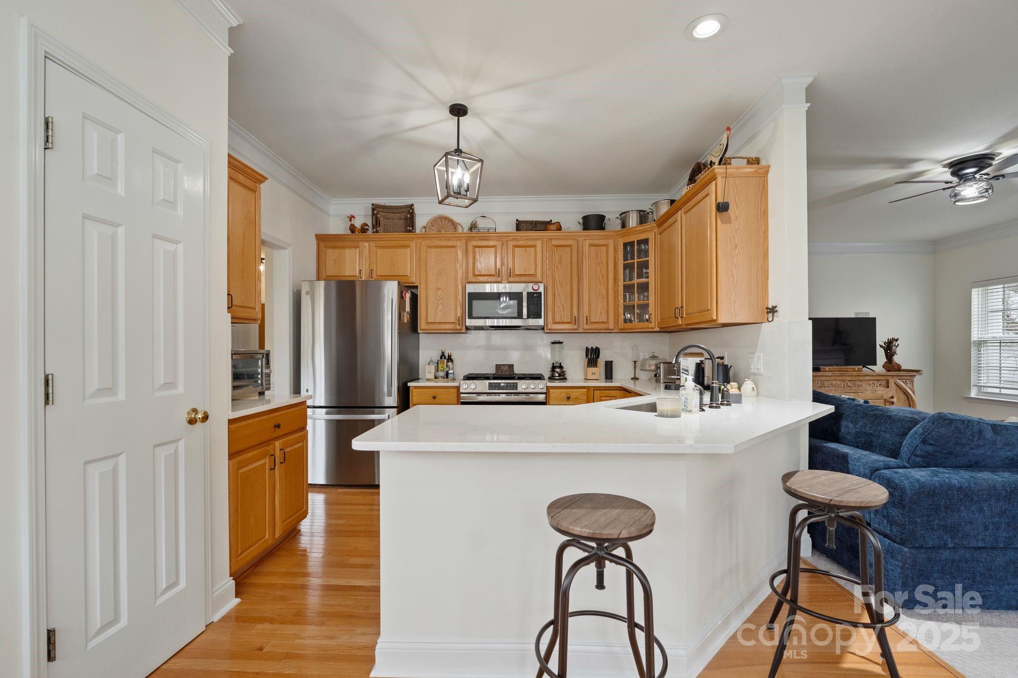 19302 Ruffner Drive Cornelius, NC 28031 - Photo 16 of 44 a kitchen with stainless steel appliances granite countertop a refrigerator a sink a stove a dining table and chairs with wooden floor