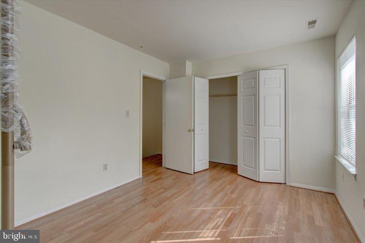 1543 Holbrook Street Baltimore, MD 21202 - Photo 3 of 23 an empty room with wooden floor and windows