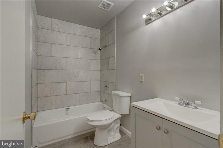 1543 Holbrook Street Baltimore, MD 21202 - Photo 5 of 23 a white toilet sitting next to a bathroom sink and vanity