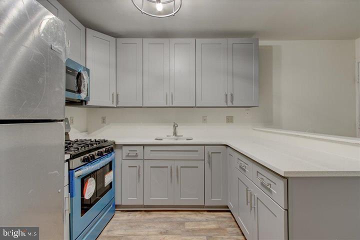 1543 Holbrook Street Baltimore, MD 21202 - Photo 7 of 23 a kitchen with stainless steel appliances a stove a sink and a microwave
