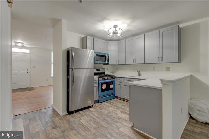 1543 Holbrook Street Baltimore, MD 21202 - Photo 8 of 23 a kitchen with stainless steel appliances a refrigerator stove microwave and cabinets