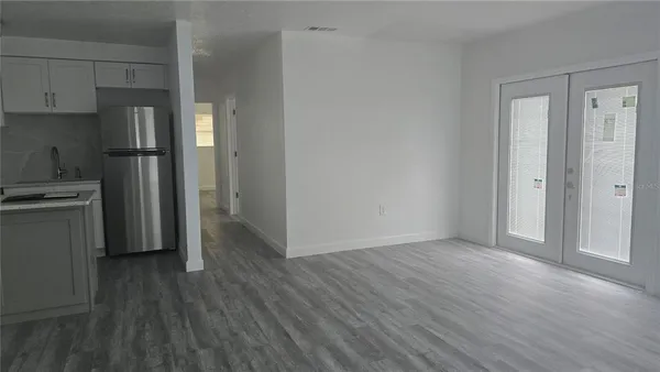 a view of a kitchen with a fridge and wooden floor
