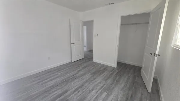 a view of a room with wooden floor and a hallway