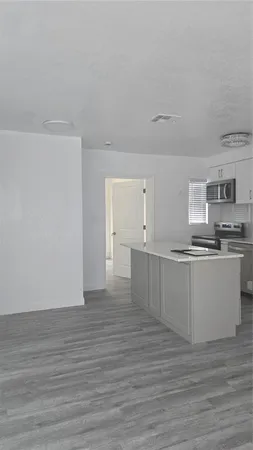 a view of kitchen with wooden floor and electronic appliances