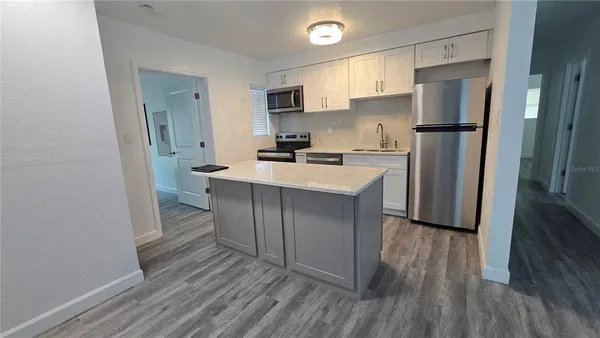 a kitchen with a refrigerator a sink and a stove top oven