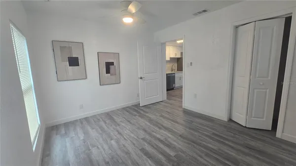 an empty room with wooden floor and windows