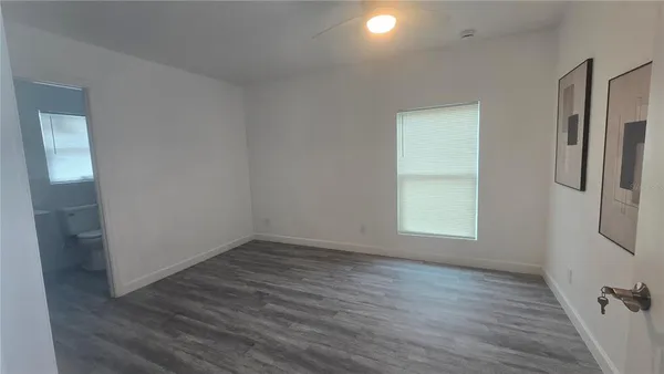 an empty room with wooden floor and a window