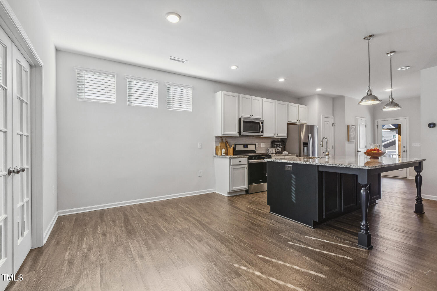 232 Big Barn Drive Wendell, NC 27591 - Photo 22 of 56 a kitchen with stainless steel appliances kitchen island granite countertop a refrigerator a sink dishwasher a stove and white cabinets with wooden floor