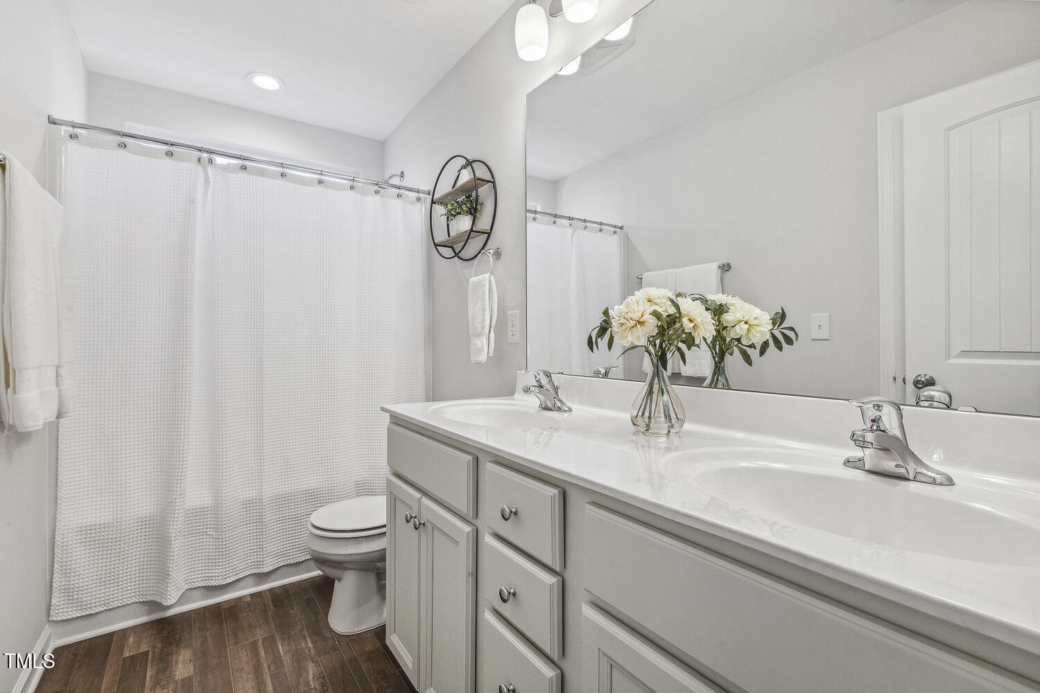 232 Big Barn Drive Wendell, NC 27591 - Photo 45 of 56 a bathroom with a granite countertop sink a toilet and a mirror