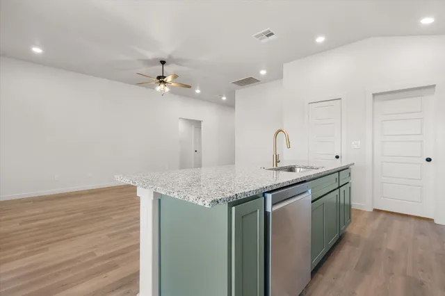 a kitchen with a sink vanity and a granite counter top