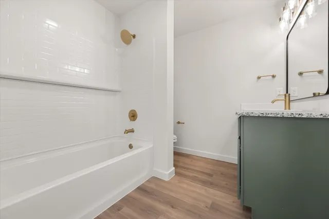 a bathroom with a granite countertop bathtub and shower