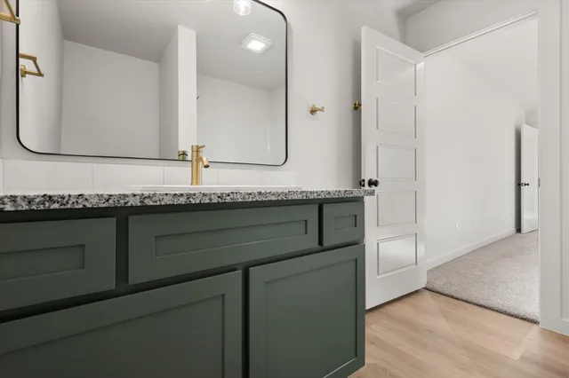 a bathroom with a granite countertop sink and a mirror