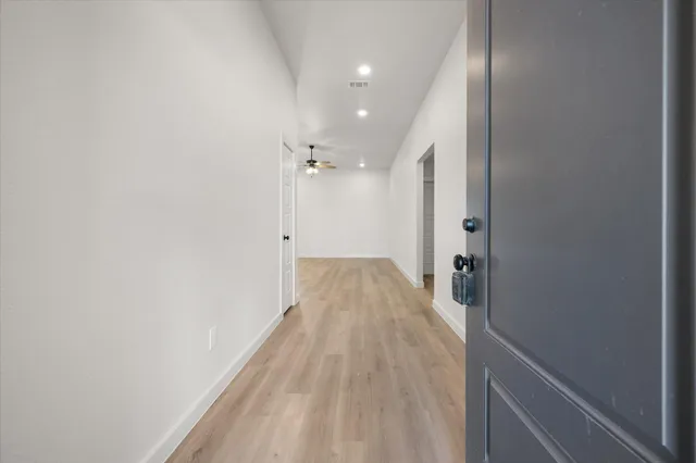 a view of a hallway with wooden floor