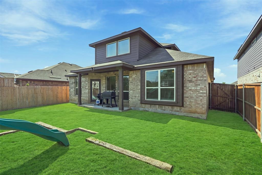 1321 Raleigh Path Denton, TX 76208 - Photo 33 of 35 Expansive green lawn with a covered patio area