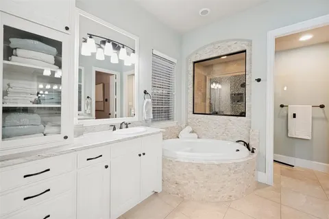 a bathroom with a tub sink and mirror