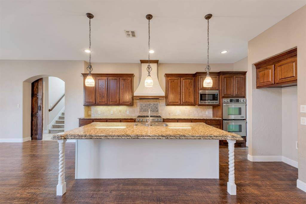 701 Buffalo Springs Drive Prosper, TX 75078 - Photo 2 of 15 a view of a kitchen with center island and wooden floor