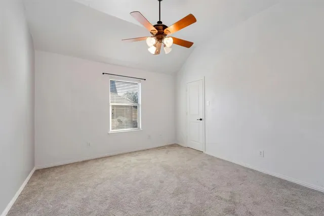 an empty room with window and chandelier fan