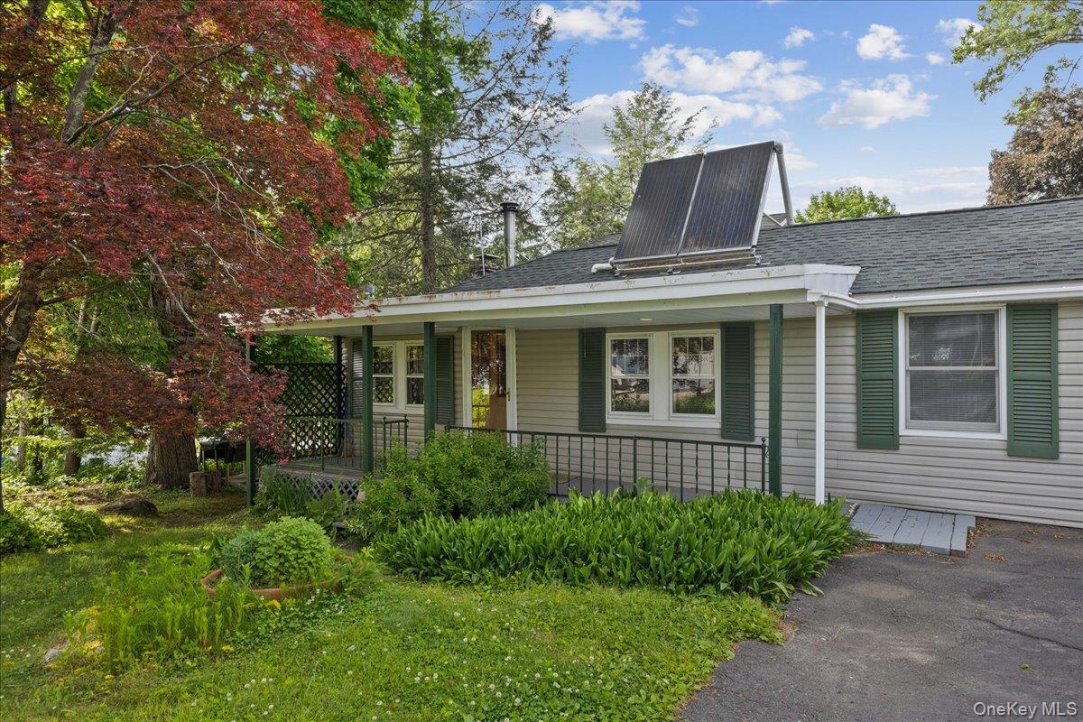 4 Brandon Road Brewster, NY 10509 - Photo 4 of 38 Ranch-style residence featuring light-colored siding, green shutters, and a covered front porch with a lattice privacy screen