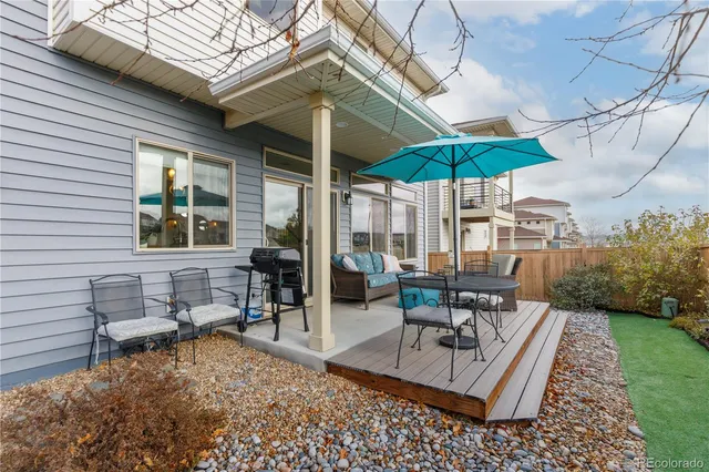 a view of a patio with a table and chairs under an umbrella