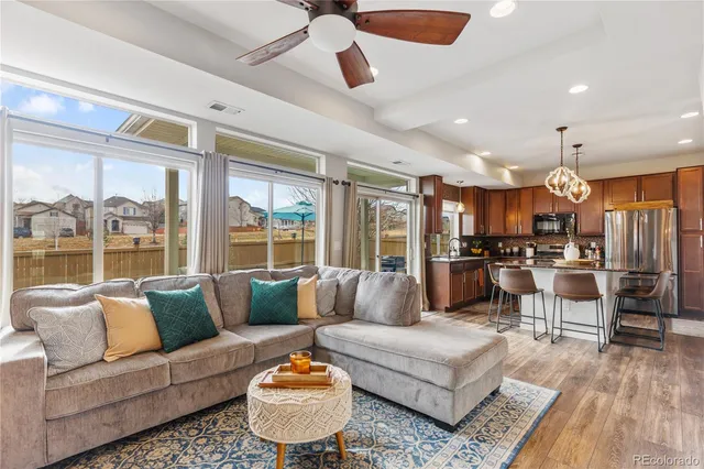 a living room with furniture kitchen and a large window