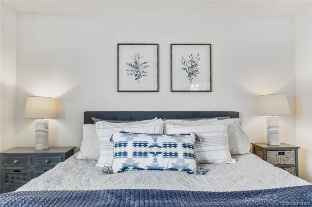 a bedroom with a bed and a lamp on dresser