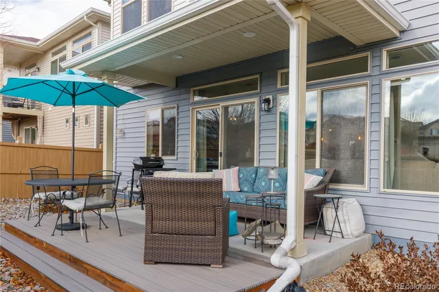 a view of a patio with table and chairs under an umbrella