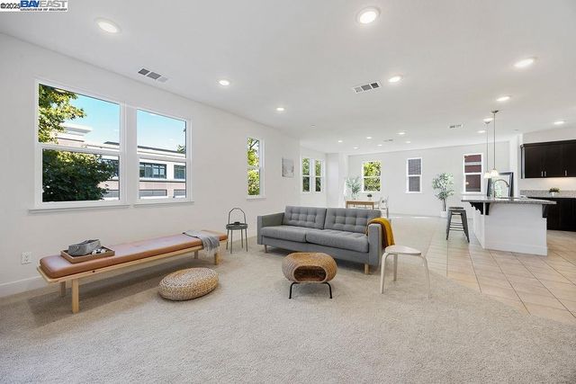 a living room with furniture a flat screen tv and kitchen view